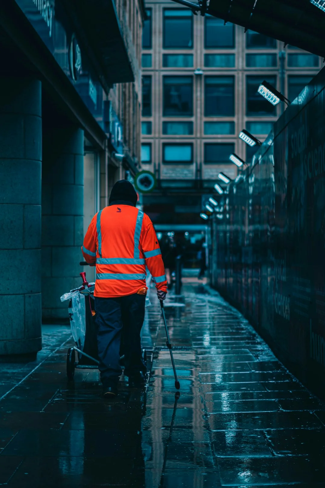A man cleaning skyscraper windows with a harness, showcasing urban high-rise work.