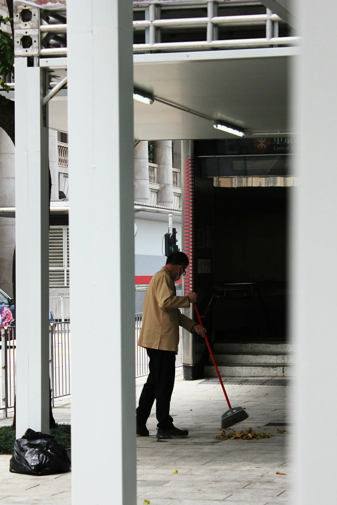Two workers clean windows on a modern glass building facade using a suspended platform.